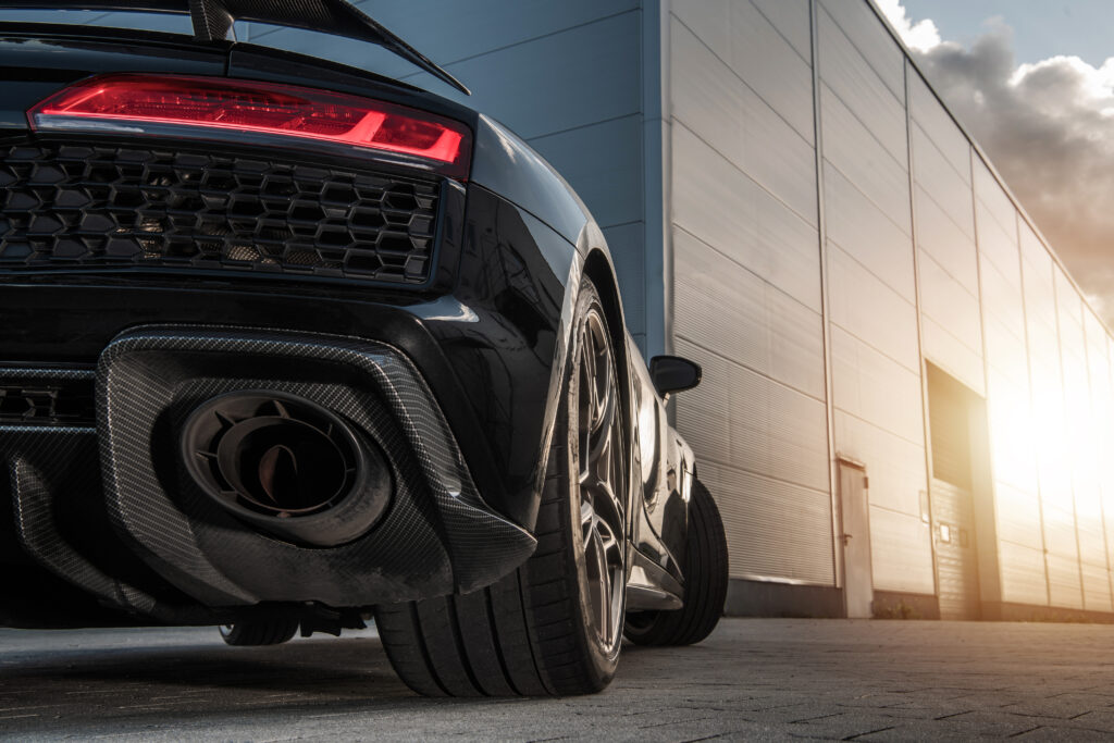 Automotive Theme. Performance Sporty Car in Front of Commercial Warehouse During Late Afternoon.